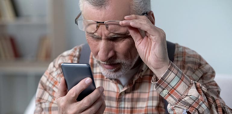 Not optimized for mobile users. Man struggling to read on his phone