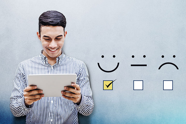 Customer Experience. Happy man holding a Tablet rating service experience with an excellent smiley face