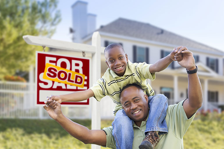 Father and son in front of their recently bought home