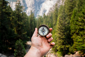 Man holding compass in the forest