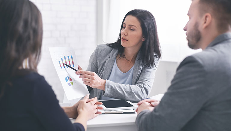 Professional woman giving financial advice to young couple