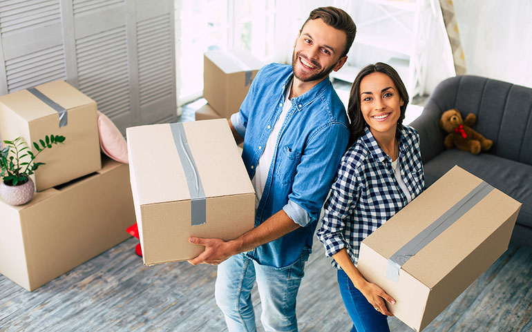 Young happy couple unpacking boxes in new home